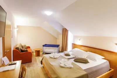 a hotel room with two beds and a couch at Hotel Vegov Hram in Dol pri Ljubljani