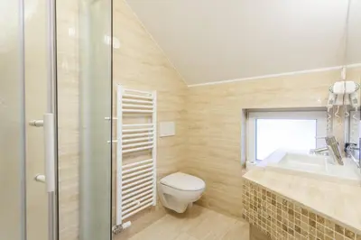 a bathroom with a toilet and a sink and a shower at Hotel Vegov Hram in Dol pri Ljubljani