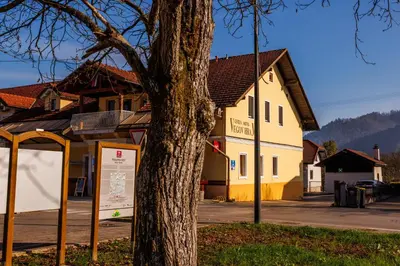 a tree with a sign in front of a building at Hotel Vegov Hram in Dol pri Ljubljani