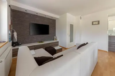 a living room with a white couch and a brick wall at Sunee Apartment in Kranjska Gora