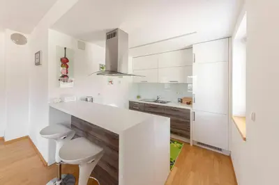 a white kitchen with a counter and a sink at Sunee Apartment in Kranjska Gora