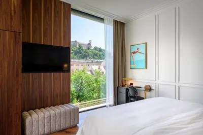 a bedroom with a bed and a large window at AS Boutique Hotel, superior in Ljubljana