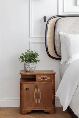 a plant on a night stand next to a bed at AS Boutique Hotel, superior in Ljubljana