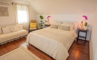 a bedroom with a large white bed and two chairs at Holiday home in Smarjeske Toplice - Kranjska Krain 45723 in Smarjeske Toplice