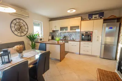 a large kitchen with a large clock on the wall at Holiday home in Smarjeske Toplice - Kranjska Krain 45723 in Smarjeske Toplice