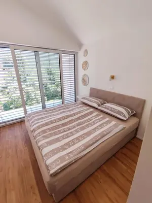 a large bed in a room with large windows at Holiday house Sara in Kozina