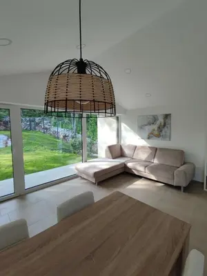 a living room with a couch and a chandelier at Holiday house Sara in Kozina