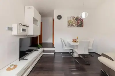 a living room with a dining room table and a tv at Cadys Apartment in Kranjska Gora