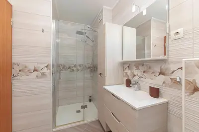a white bathroom with a shower and a sink at Cadys Apartment in Kranjska Gora