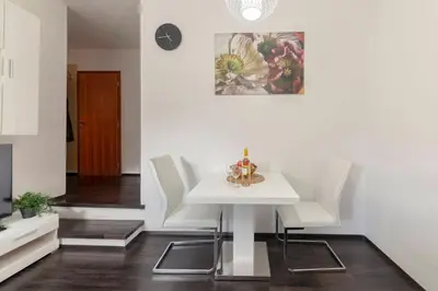 a dining room with a white table and white chairs at Cadys Apartment in Kranjska Gora