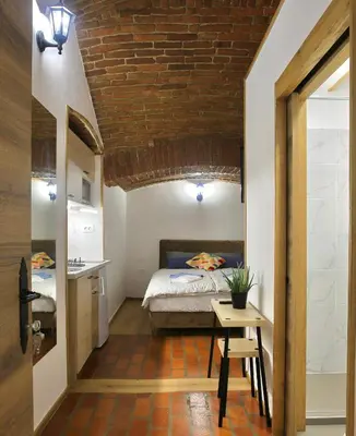 a bedroom with a bed and a table in a room at Podroom Apartments in Ljubljana
