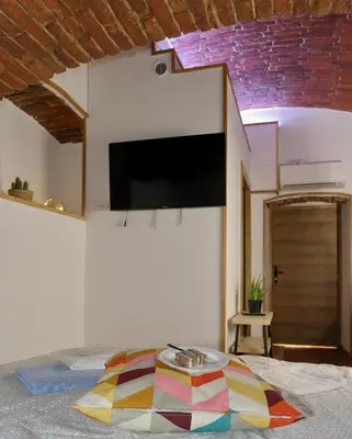 a bed with a colorful pillow on the floor in a room at Podroom Apartments in Ljubljana