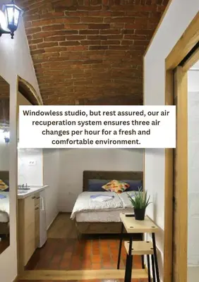 a bedroom with a bed and a brick wall at Podroom Apartments in Ljubljana