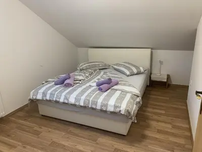 a bedroom with a bed with purple stuffed animals on it at Apartment Teja in Brezovec