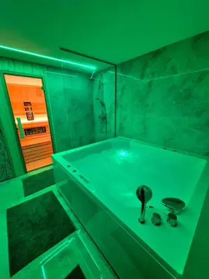 a green bathroom with a tub with two mugs at Apartment Teja in Brezovec