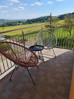 two chairs and a table on a balcony with a view at Apartment Carolina in Rogašovci