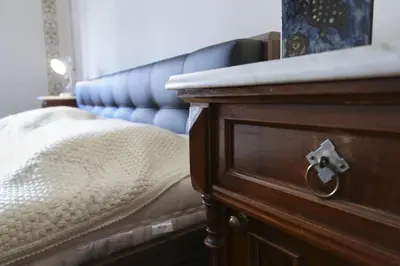 a bedroom with a bed and a wooden dresser at New boutique apartments house Gabrijela Mrak in old Tolmin in Tolmin