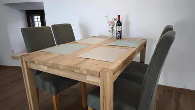 a wooden table with chairs and a bottle of wine at New boutique apartments house Gabrijela Mrak in old Tolmin in Tolmin
