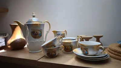 a group of cups and tea pots on a wooden table at New boutique apartments house Gabrijela Mrak in old Tolmin in Tolmin