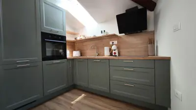 a kitchen with gray cabinets and a sink and a microwave at New boutique apartments house Gabrijela Mrak in old Tolmin in Tolmin