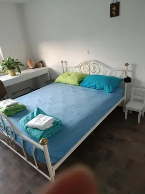 a bed with blue sheets and green pillows in a room at Apartma Dobrodošli pri Renati v Celju in Celje