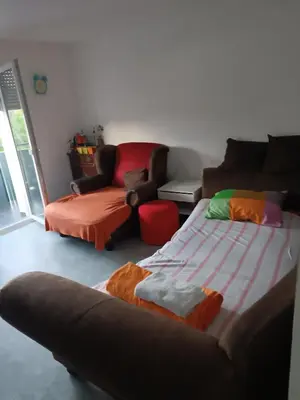 a living room with a bed and a chair at Apartma Dobrodošli pri Renati v Celju in Celje