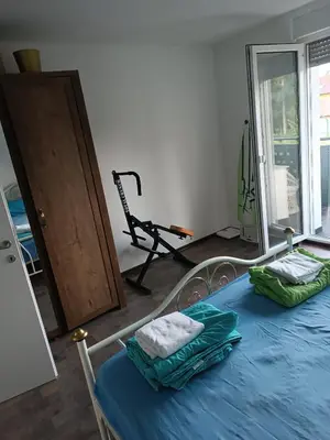 a bedroom with a bed with blue sheets and a treadmill at Apartma Dobrodošli pri Renati v Celju in Celje
