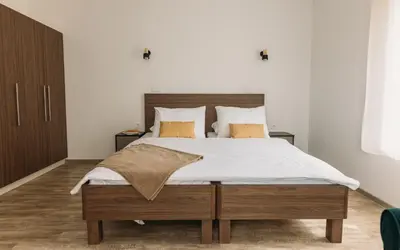 a bedroom with a large bed with white sheets and orange pillows at Hiša na Ravnah in Pišece