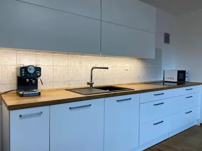 a kitchen with white cabinets and a sink at Spacious APT in a Quiet Neighbourhood + Private Parking in Ljubljana