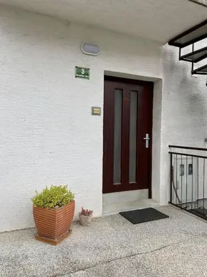 a door of a house with a plant in front of it at Spacious APT in a Quiet Neighbourhood + Private Parking in Ljubljana