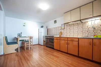 a large kitchen with wooden cabinets and a table in it at Hostel, Rooms and Apartment Ceklin in Bohinj