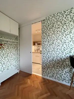a living room with a wall with a glass door at Studio with a view on City center park in Maribor