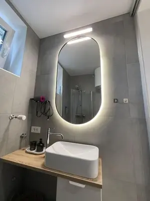 a bathroom with a white sink and a mirror at Studio with a view on City center park in Maribor