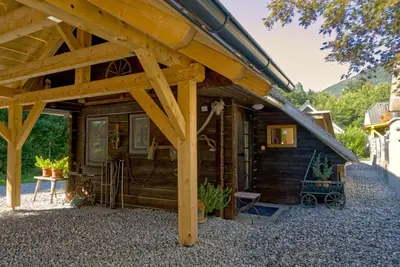 a log cabin with a large wooden roof at Koča Kopriva in Križe