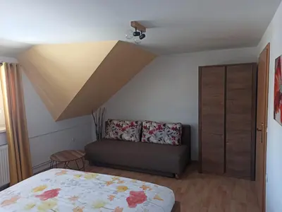 a bedroom with a bed and a couch at Apartments Skok in Bled