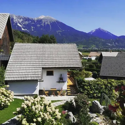 a white house with a mountain in the background at Apartments Skok in Bled