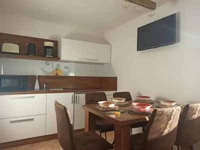 a kitchen with a wooden table with chairs and a kitchen at Apartments Skok in Bled