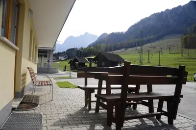a group of benches sitting outside of a building at Apartments Rožič in Kranjska Gora