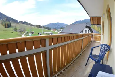 a balcony with a chair and a view of the mountains at Apartments Rožič in Kranjska Gora