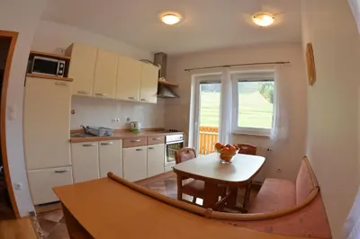 a kitchen with a table and a small kitchen with a window at Apartments Rožič in Kranjska Gora