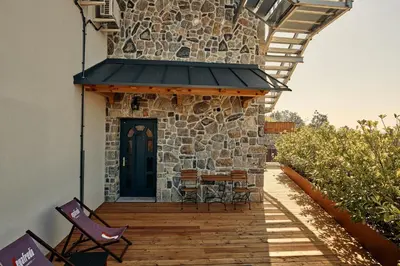 a patio with chairs and a table and a building at Gostilnica Orle - Sleeping in the tower in Škofljica