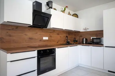 a kitchen with white cabinets and a tv on the counter at Jacobs Legacy - 4 Bedroom House, Free Parking, near City Center in Ljubljana
