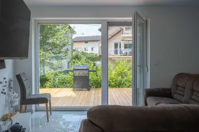 a living room with a sliding glass door to a patio at Jacobs Legacy - 4 Bedroom House, Free Parking, near City Center in Ljubljana