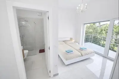 a white bedroom with a bed and a shower at Jacobs Legacy - 4 Bedroom House, Free Parking, near City Center in Ljubljana