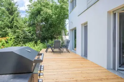 a wooden deck with a table and chairs on a house at Jacobs Legacy - 4 Bedroom House, Free Parking, near City Center in Ljubljana