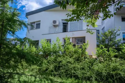 a white house with trees in front of it at Jacobs Legacy - 4 Bedroom House, Free Parking, near City Center in Ljubljana