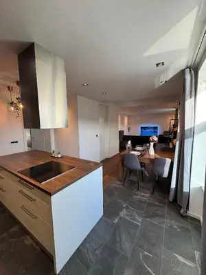 a kitchen with a sink and a table with chairs at Apartment Bacci in Vrhnika