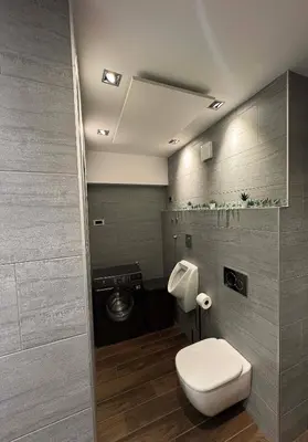 a bathroom with a toilet and a washing machine at Apartment Bacci in Vrhnika