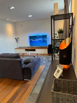 a living room with a blue couch and a tv at Apartment Bacci in Vrhnika