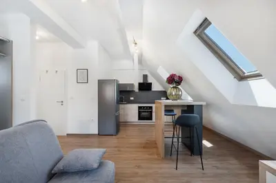 a kitchen with a stainless steel refrigerator and a table at SMART APARTMENT LJUBLJANA in Spodnja Šiška